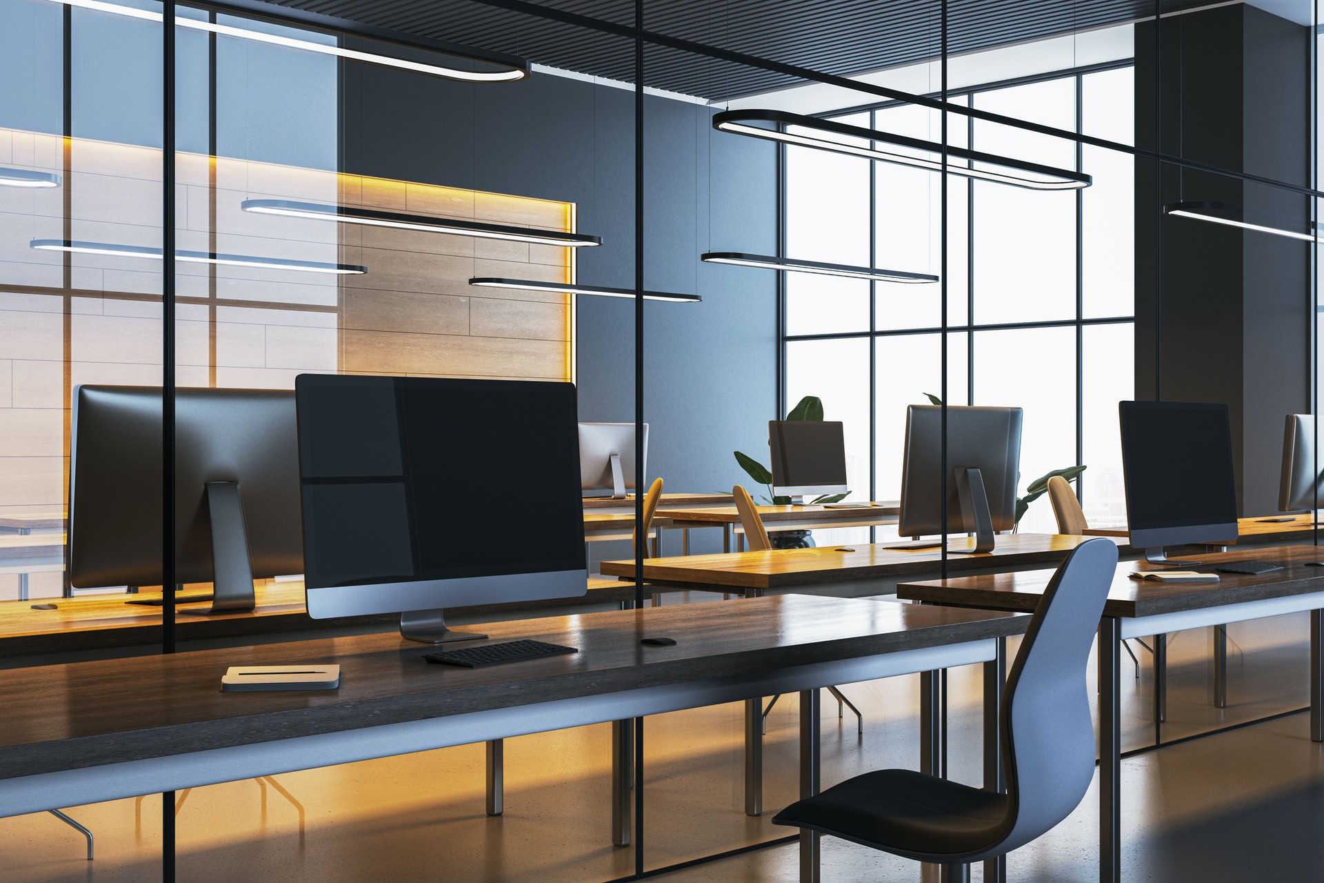 Modern office interior with desks, computers, and chairs surrounded by glass partitions and warm lighting in a clean, organized workspace. 3D Rendering